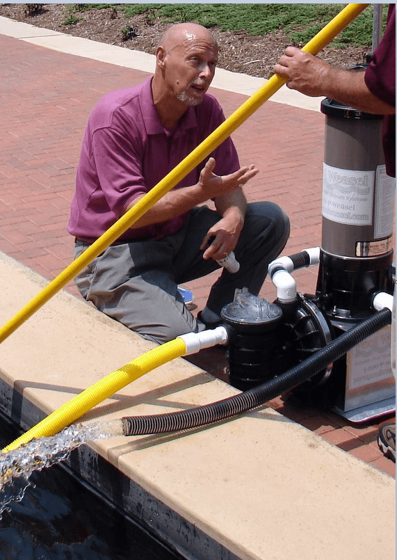 Tom S. Jones, Pool Weasel founder, demonstrating the vacuum system poolside